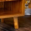 Enhance your space with The Single Drawer Teak Nightstand, featuring solid teak wood, natural satin finish, and a practical open drawer design.